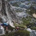 several mountain climbers on cliff of rock mountain at daytime